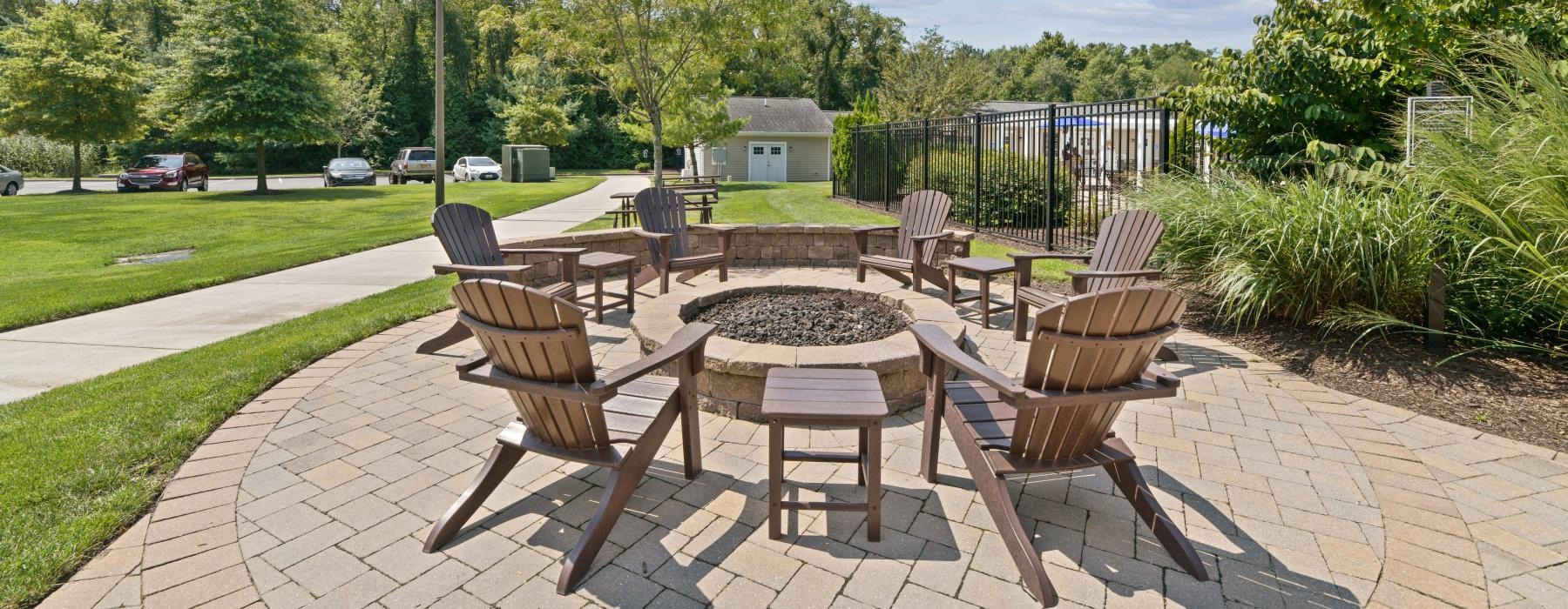 a patio with chairs and tables near lush green turf
